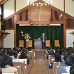 天城山荘の聖堂で、山本浩学長の講話を聴く新入生たち